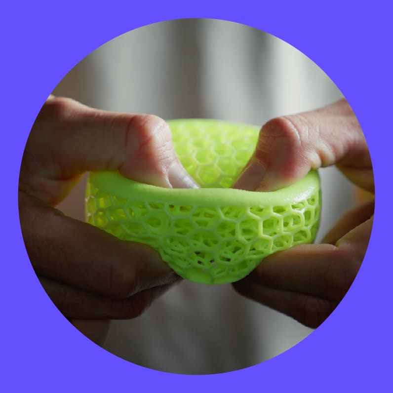 Hands squeezing an elastomeric latticed puck